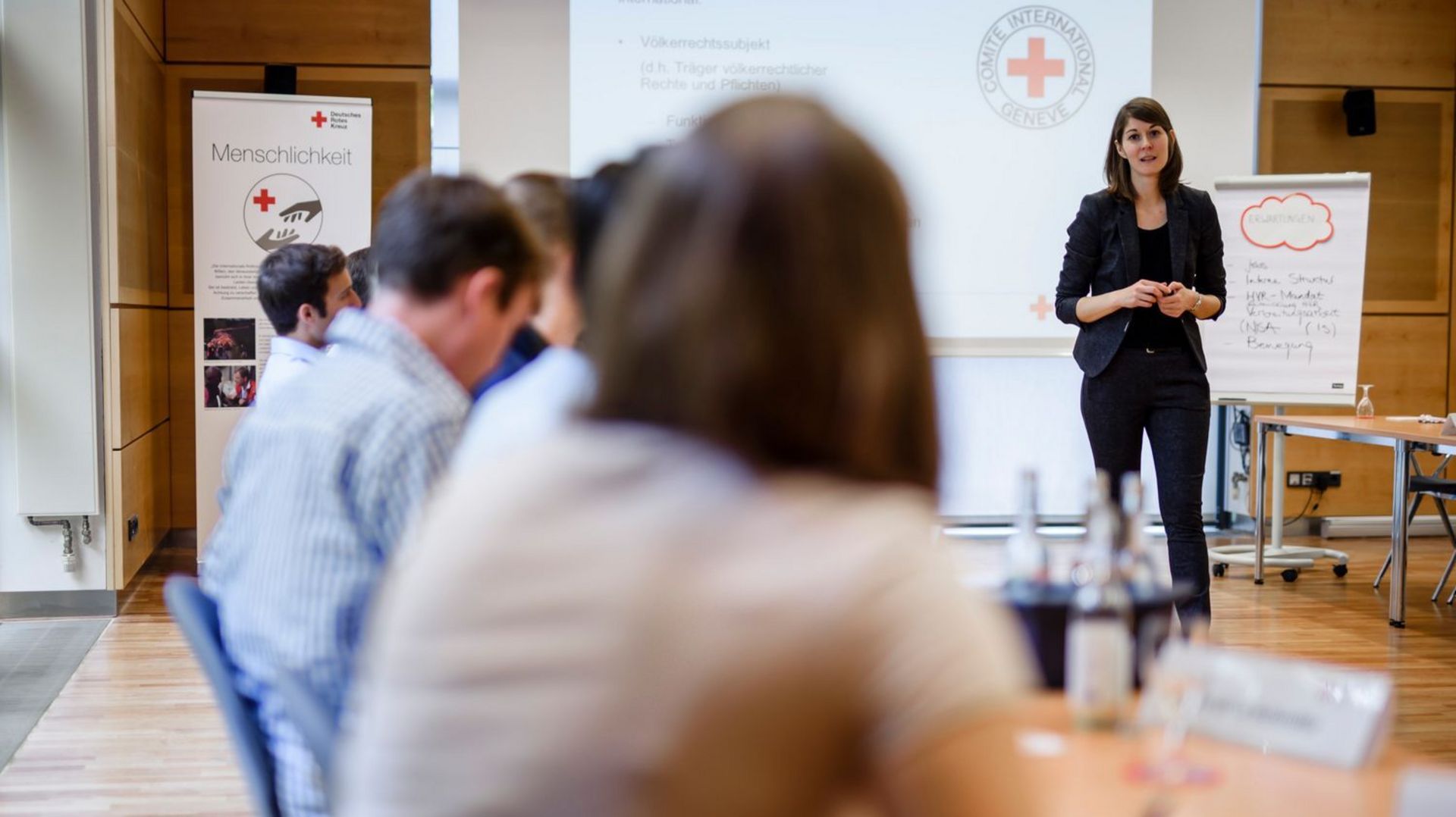 Referentin für Verbreitungsarbeit Katja Schöberl unterrichtet in einem Seminarraum im DRK Generalsekretariat Jurastudenten