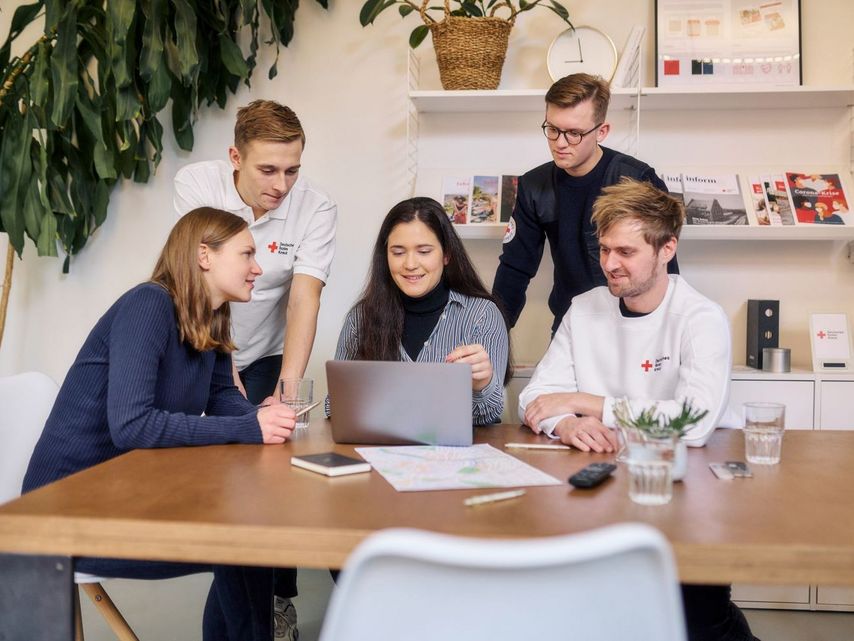 Team des DRK sitzt um den Tisch herum bei einer Besprechung