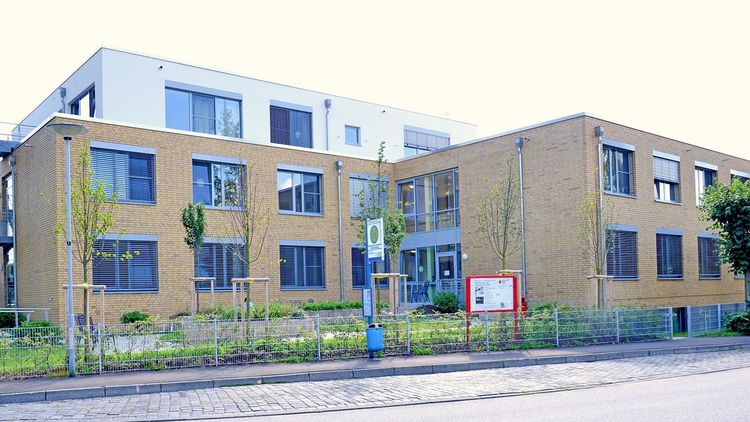 Das DRK Senioren- und Pflegezentrum im Park von außen, ein modernes gelbliches Gebäude