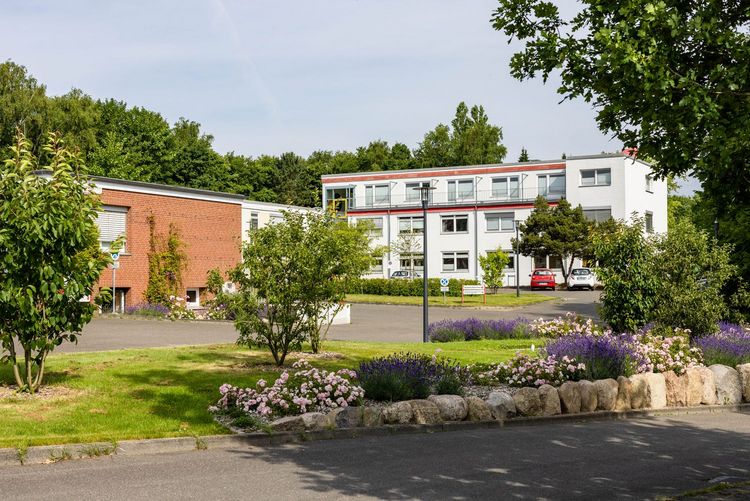 Blick auf ein weißes und ein braunes Gebäude des DRK-Standorts Raisdorf