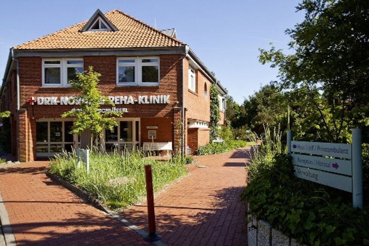 Haupteingang der DRK-Nordsee-Reha-Klinik Goldene Schlüssel, mit viel Grünfläche drumherum